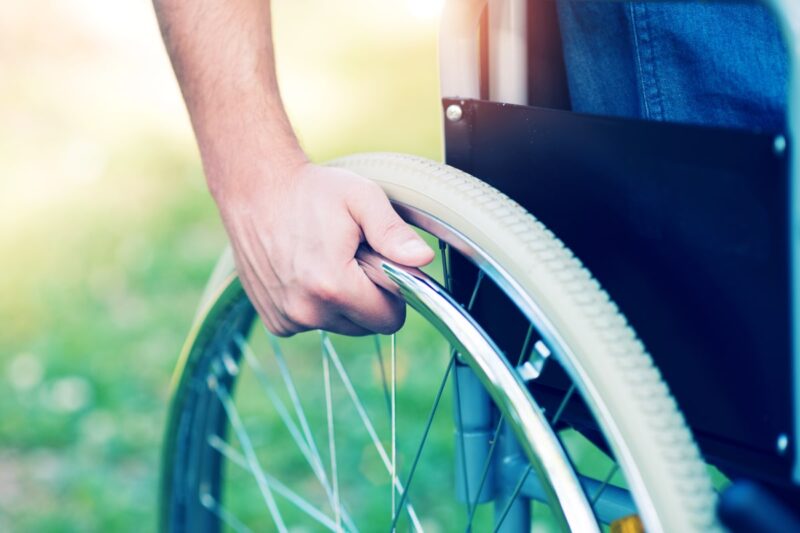 Closeup of a hand on a wheelchair wheel