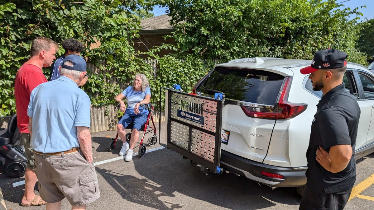 Midwest Mobility employees and customers next to a newly installed vehicle lift on the customers vehicle