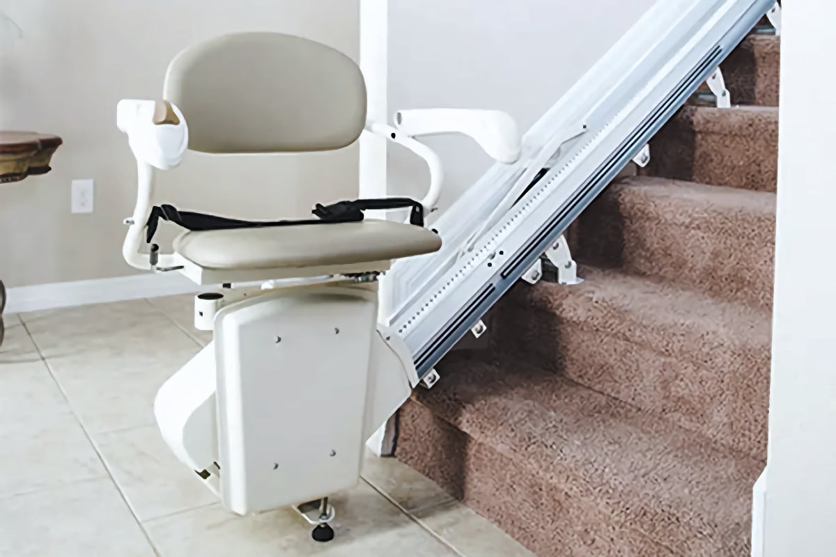 stair lift chair at the bottom of a set of stairs in a home