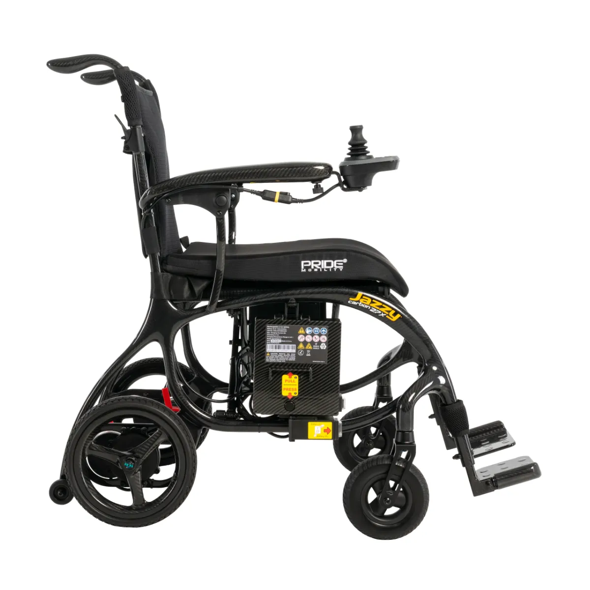 A black Pride Mobility Jazzy Carbon 27X power wheelchair shown in profile. The lightweight design features a visible carbon fiber frame, footrests, and a joystick control unit on the right armrest.