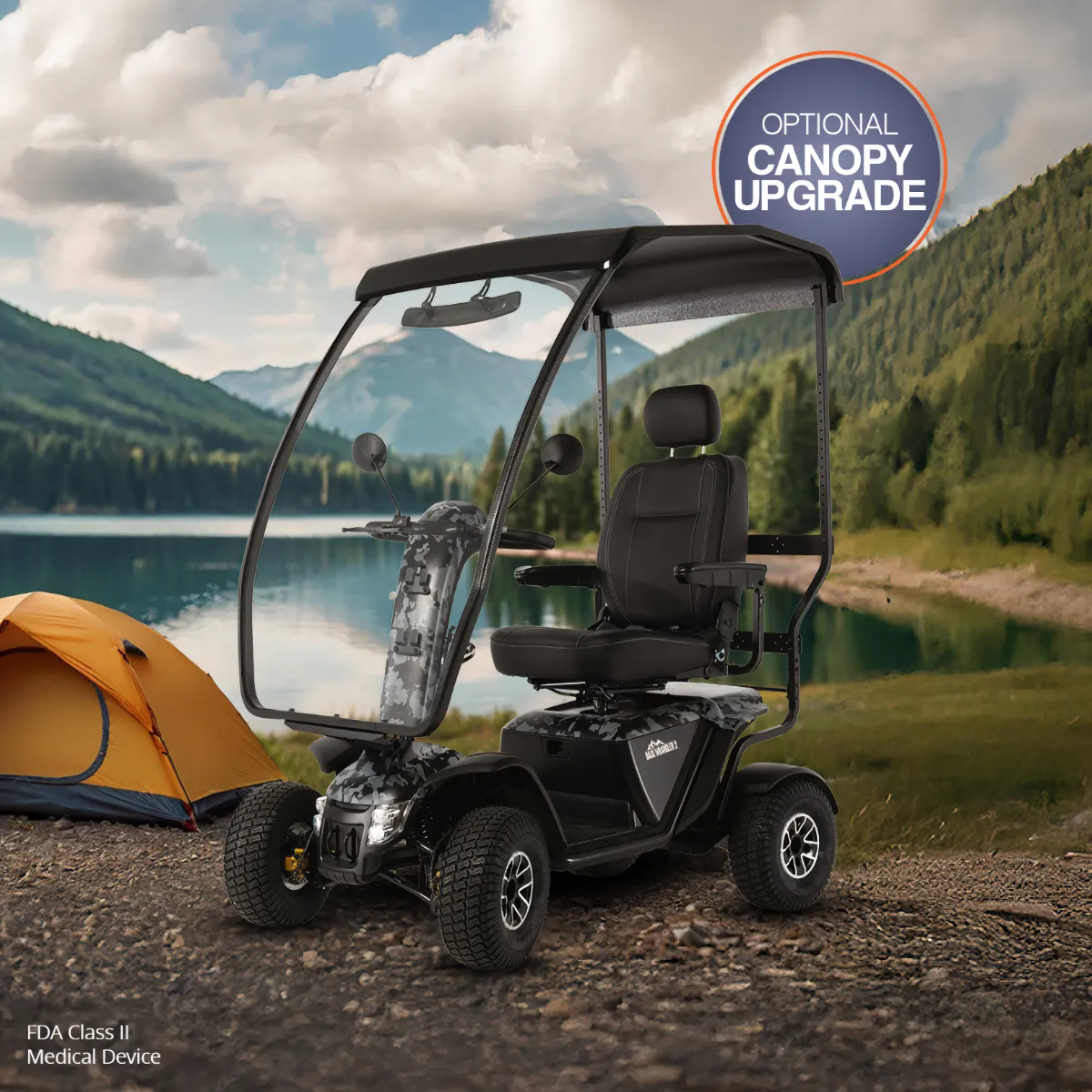 A black off-road mobility scooter with large tires and a protective canopy upgrade is parked on a dirt trail next to an orange tent, overlooking a mountain lake.
